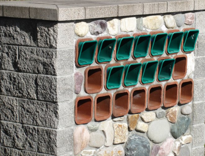 Paperboxes in front of a gated community.